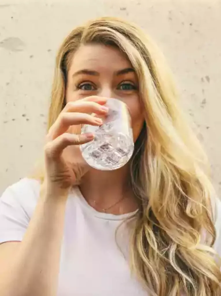 Une personne buvant dans un verre d'eau
