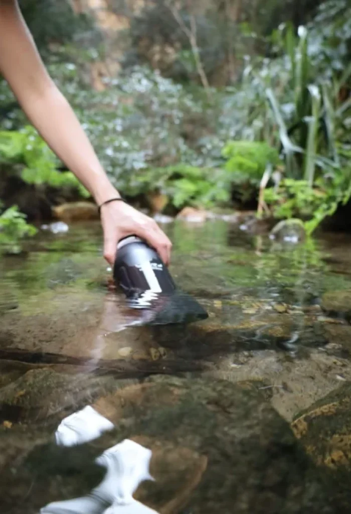 Remplissage de la gourde filtrante dans une rivière