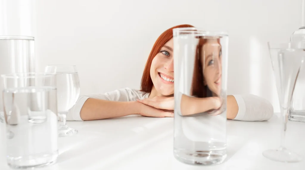 Une femme derrière un verre d'eau